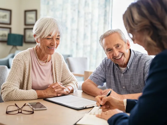 Smiling senior couple meeting with a financial advisor to discuss their estate planning.